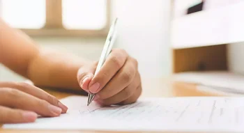 Main écrivant sur un document officiel concernant le report du paiement des loyers.