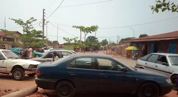 Scène urbaine à Bohicon où des taximen contournent le cordon sanitaire avec leurs véhicules.