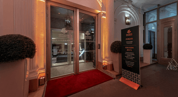 Entrée prestigieuse du Club Pierre Charron avec un tapis rouge et des détails architecturaux raffinés.