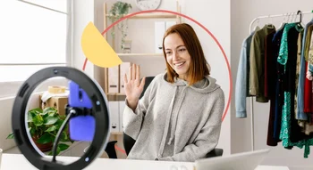 Jeune femme créant du contenu vidéo dans son studio pour son activité secondaire.