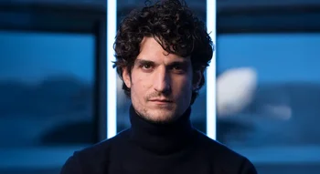 Louis Garrel en portrait serré dans une lumière bleutée moderne.