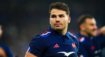 Antoine Dupont observant le jeu en maillot bleu du XV de France.