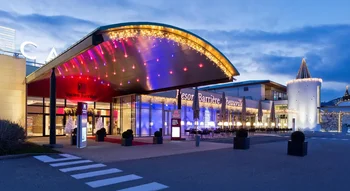 Image du Casino Barrière Ribeauvillé illuminé la nuit avec une entrée élégante et des lumières colorées.