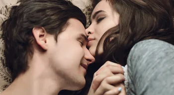 Couple amoureux allongé sur un lit, partageant un moment tendre.