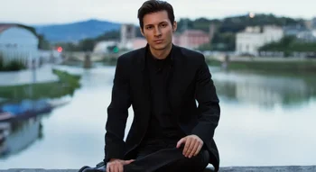 Pavel Dourov assis près d’une rivière, vêtu de noir, regard calme et posé.