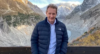 Lionel Tardy devant un paysage alpin.