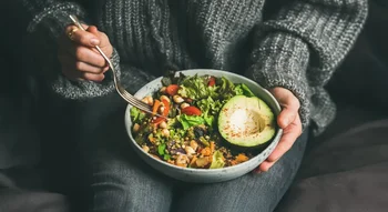 Bol végétarien garni de quinoa, avocat et légumes frais.