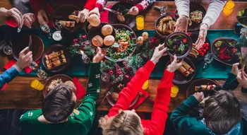 Repas de fête familial convivial, autour d’une table garnie de plats traditionnels incluant de la viande.
