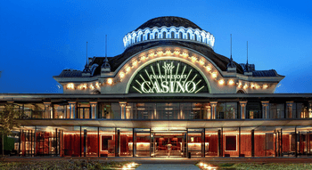 Façade illuminée du Casino d'Évian Resort en soirée, vue depuis l'entrée principale.