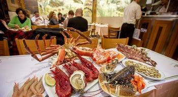 Assortido de marisco sobre uma mesa branca: ostras, camarões e crustáceos na Cervejaria Ramiro