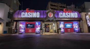 Façade illuminée du Casino Juan‑les‑Pins du Groupe Partouche en soirée.
