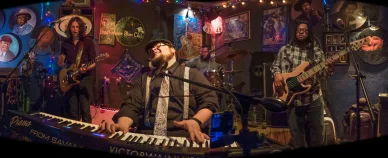 Concert blues en direct sur la scène du Bradfordville Blues Club avec groupe et public.