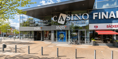 Casino Flensburg mit Haupteingang, Glasfassade und angrenzenden Geschäften