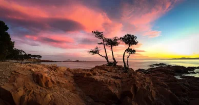 Paysage rocheux et ciel flamboyant à la Plage de Palombaggia. Coucher de soleil aux couleurs vives sur la Plage de Palombaggia en Corse.