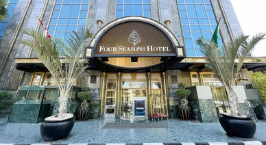 المدخل الرئيسي لفندق فور سيزونز (Four Seasons Hotel) الفاخر، يتميز بواجهته العصرية وأشجار النخيل.