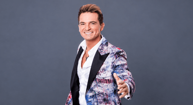 Jorge Guerreiro sorri de blazer estampado e camisa branca