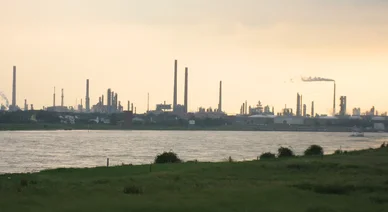 Paysage industriel avec usines et cheminées représentant l’Industrie moderne près d’un fleuve.