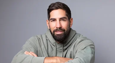 Nikola Karabatic en sweat gris, les bras croisés.