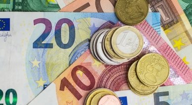 Billets de banque en euros avec des pièces empilées.