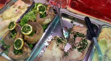 Vitrine de plats à base de poisson et de viande présentés dans des bacs en inox, soulignant l’importance de l’Hygiène alimentaire.