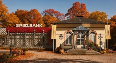 Herbstliche Außenansicht der Spielbank Bad Homburg mit goldenen Bäumen, Bank und Kürbissen am Eingang