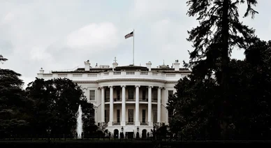Façade de la Maison-Blanche entourée de végétation, illustrant le développement responsable des actifs numériques.