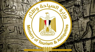 علامة وزارة السياحة والآثار المصرية التي تتوسطها صورة نسر صلاح الدين بألوان علم مصر، معروضة على خلفية لجدران حجرية أثرية مزينة بالكتابة الهيروغليفية.