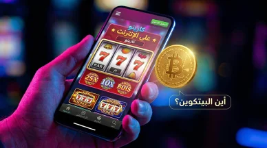 كازينو البيتكوين اون لاين على الهاتف المحمول يد تحمل هاتفاً ذكياً يعرض ألعاب ماكينات القمار في كازينو اون لاين مع عملة بيتكوين ذهبية وسؤال أين البيتكوين.