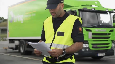 ضابط جمركي يدقق في وثائق الشحن الخاصة بشاحنة استعداداً لإصدار تصريح الإفراج عن البضائع.