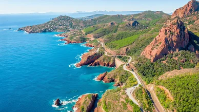 Panorama côtier spectaculaire le long de la Corniche d’Or, Massif de l’Esterel. Vue aérienne de la Corniche d’Or, falaises rouges et mer turquoise du Massif de l’Esterel.