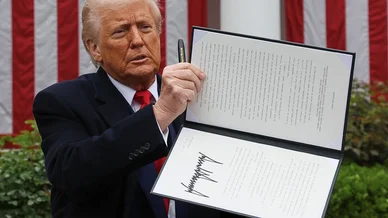 دونالد ترامب يعرض وثيقة تنفيذية موقعة أمام العلم الأمريكي دونالد ترامب (Donald Trump)