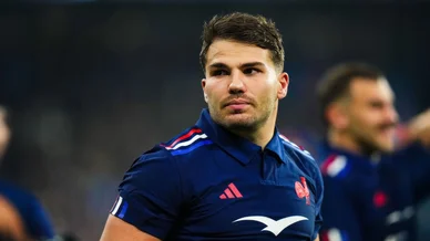 Antoine Dupont observant le jeu en maillot bleu du XV de France.