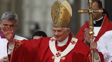 Le pape Benoît XVI en vêtement liturgique rouge bénit les fidèles pendant la visite du pape Benoît XVI au Portugal.