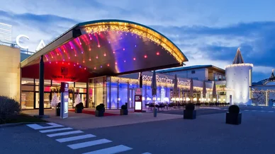 Image du Casino Barrière Ribeauvillé illuminé la nuit avec une entrée élégante et des lumières colorées.