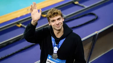 Léon Marchand salue le public après une médaille aux Mondiaux.