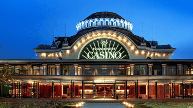 Façade illuminée du Casino d'Évian Resort en soirée, vue depuis l'entrée principale.