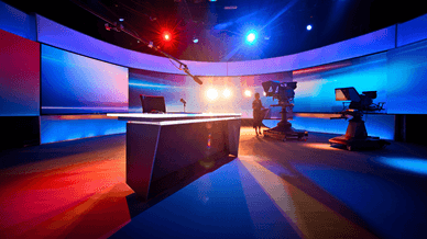 Modernes deutsches Fernsehstudio mit Moderatorenpult, Kameras und bunter Studiobeleuchtung