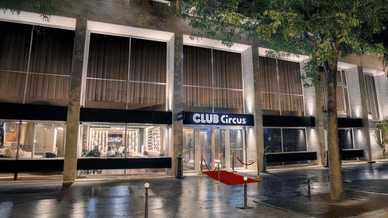 Entrée élégante du Club Circus Paris avec tapis rouge et éclairage nocturne.