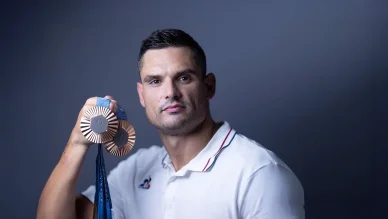 Florent Manaudou présente fièrement ses médailles de bronze. Florent Manaudou tenant ses médailles de bronze olympiques.