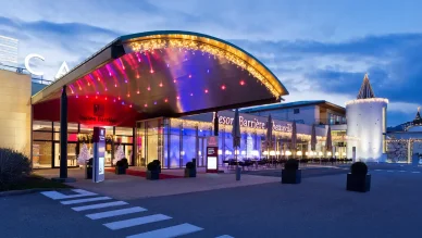 Image du Casino Barrière Ribeauvillé illuminé la nuit avec une entrée élégante et des lumières colorées.