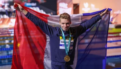 Sous le drapeau tricolore, Léon Marchand célèbre son titre mondial.