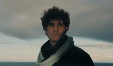 Louis Garrel filmé en extérieur dans un paysage dramatique aux tons froids.