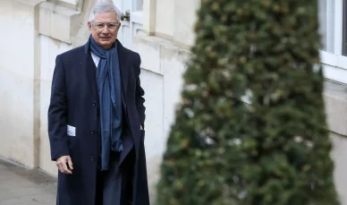 Claude Bartolone marchant en manteau sombre et écharpe bleue.