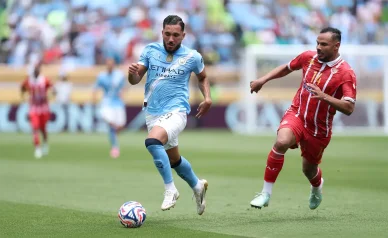 Rayan Cherki joue pour Manchester City pendant un match officiel. Rayan Cherki en action avec Manchester City lors d’un match de football.
