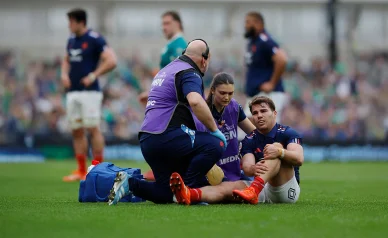 Antoine Dupont blessé au genou soigné par le staff médical.