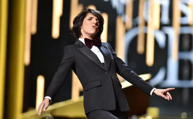 Florence Foresti en smoking et nœud papillon, dans une pose de danse dynamique sur la scène des César.
