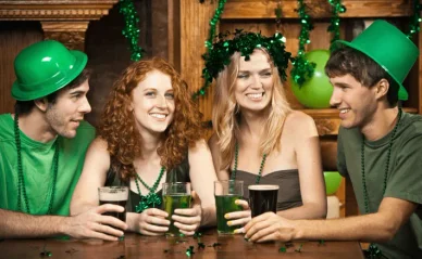 Irish people dressed in clothing with national colors of green, white, and orange