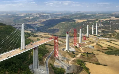 Chantier de construction du Viaduc de Millau avec pylônes et grues.