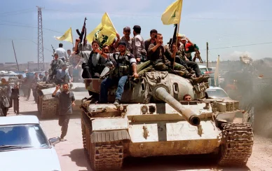 مقاتلو حزب الله على دبابة يرفعون الأعلام خلال انسحاب القوات الإسرائيلية من جنوب لبنان عام 2000