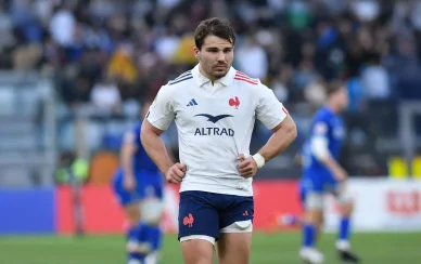 Antoine Dupont en maillot blanc courant sur le terrain avec l’équipe de France.